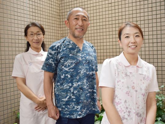 笑顔のスタッフ3人の浴室前  