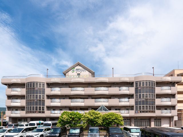 広々とした施設 外観 堂々とした建物は、働きやすい環境を提供するために設計されています。青空が広がる広々としたスペースです。