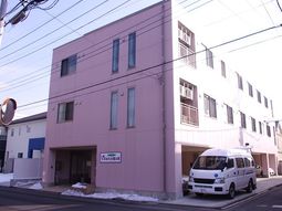 ピンクの建物と送迎車