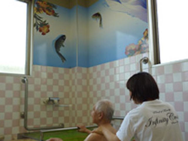 介助風景の浴室 浴室 介助を受けながら、落ち着いた雰囲気で入浴ができる癒しの空間です。壁の絵が穏やかな気分を演出しています。