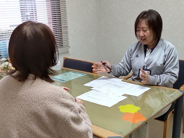 相談する人々がいる部屋 居室 暖かな光が差し込む交流スペースです。居心地の良さを大切にした設計が魅力です。
