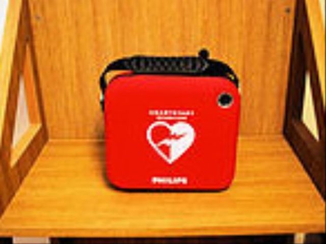 赤いAED設置の通路 AED 廊下には万一に備えたAEDが設置されており、安心して業務に取り組むことができます。
