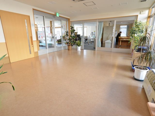 広々とした清潔なエントランス 交流ホール 広々とした開放感のある入り口は、訪れる人々を明るく迎え入れます。植物が飾られた温かみのある雰囲気で、やすらぎと安心を提供します。