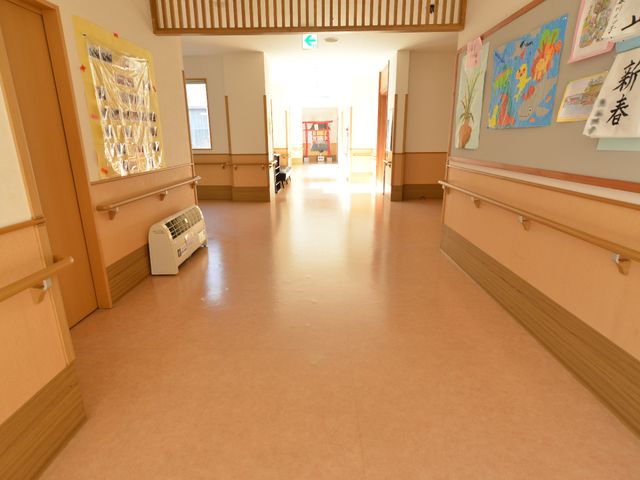廊下の清潔な空間 廊下 明るく広々とした廊下は、清潔感があり、壁に飾られたアートが暖かい雰囲気を醸し出しています。利用者様のゆとりある移動をサポートする設計です。