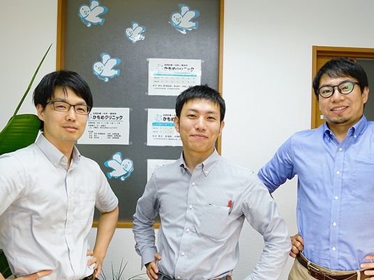 スタッフが並ぶ掲示板前  