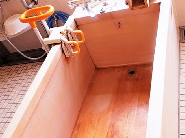 木製の浴槽 浴室 手すり付きで安全性に配慮された温かみのある浴室です。使い勝手を考えて設計されており、日々のリラックスタイムに適しています。