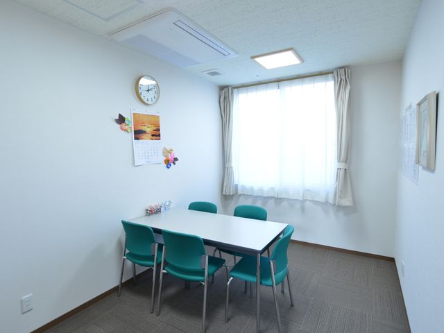清潔感のある多目的室 相談室1 シンプルで明るい多目的室は、打ち合わせやアクティビティに適した空間です。必要な情報も壁に掲示され、利便性が考慮されています。