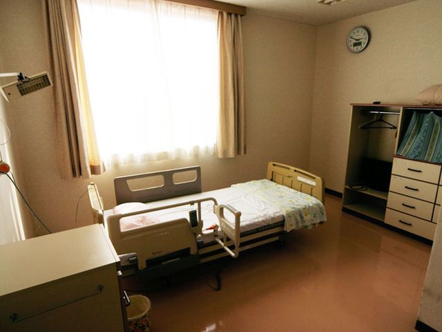 ベッドと家具が配置された居室 居室 自然光が心地良く差し込む居室で、ベッドや収納家具が配置されています。リラックスできる環境が整っています。