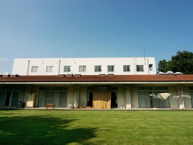 広々とした庭の施設 外観 広々とした庭と白い建物が特徴的です。開放的な環境の中での勤務が可能です。