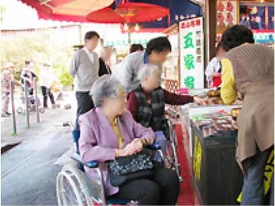 車椅子の高齢者と市場