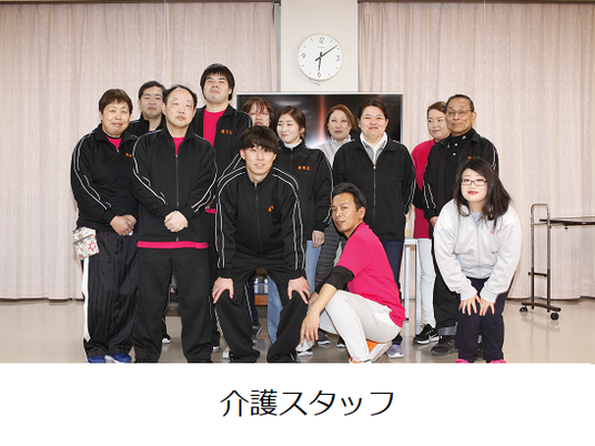 介護スタッフが並ぶ室内  