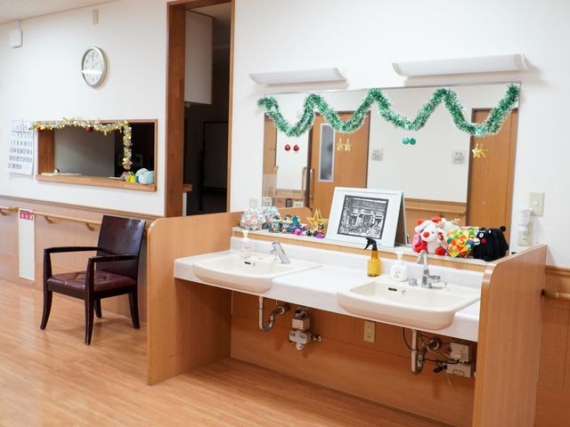 洗面台と飾り付けの廊下 洗面台 装飾が施された廊下の片隅には、使いやすい高さの洗面台が設置され、清潔感あふれる環境です。