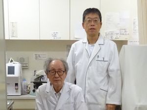 医療用白衣の職員2人、診察室  