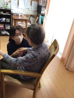 手を取り合うスタッフと利用者