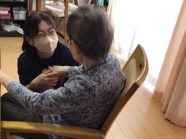 手を取り合うスタッフと利用者 ケア 暖かい雰囲気の中で、手を取り合って笑顔を交わすスタッフと利用者様。人の温もりが感じられる場です。