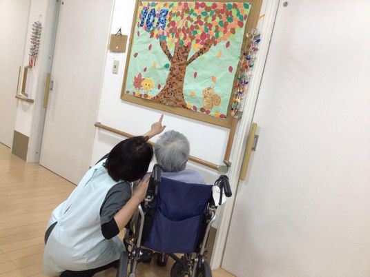 壁画を見る人とスタッフ