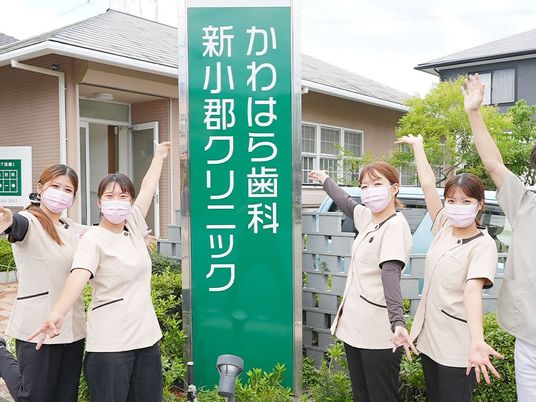 スタッフが看板前で並ぶ外観  