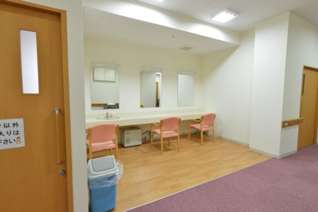 清潔な空間の多目的室 鏡台 明るく広々とした多目的室では、様々な活動を行うことができ、使い勝手の良い環境が整っています。椅子や机も用意されており、スタッフや利用者の交流の場となっています。