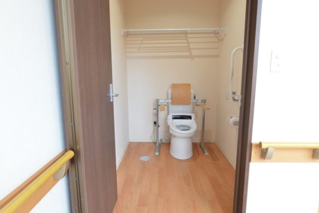 バリアフリートイレの室内 トイレ 手すりが備え付けられた清潔なトイレです。利用者の安全と快適さを考慮した配慮が感じられます。