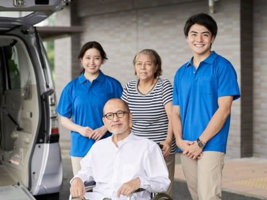 送迎車前のスタッフと利用者  