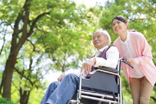 車椅子の高齢者と介助者