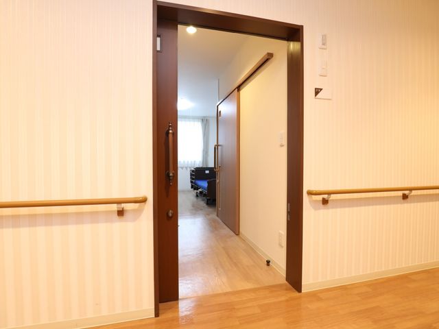 廊下に手すり付き開口部 居室 安全を考慮した設計の廊下です。手すりが設置されており、安定した移動が支援される空間が広がっています。