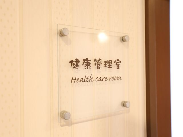 健康管理室のドアサイン 健康管理室  清潔感のあふれる壁に設置された看板は、入居者様の健康を支える空間への入口です。サポートが必要な方も、ここで安心を得られるでしょう。