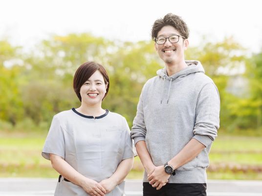 笑顔のスタッフ2人が並ぶ庭  