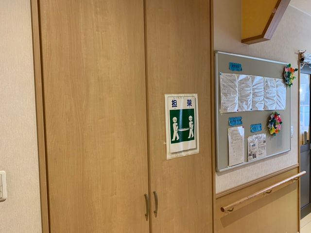 安全掲示の廊下 廊下 情報掲示板には注意事項が貼られています。廊下は木目調で落ち着いた印象です。