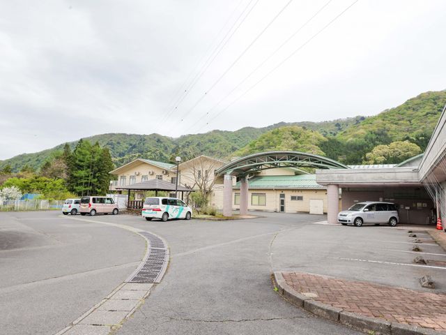 山に囲まれた建物の外観 外観 広い駐車スペースが特徴です。自然豊かな環境で、快適に働けます。