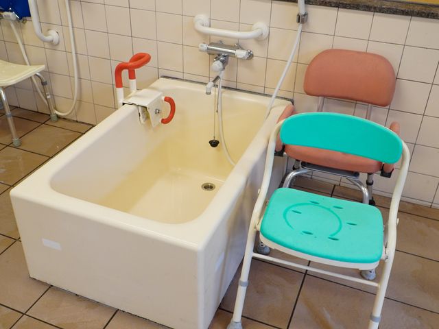 バリアフリー設計の浴室 浴室 サポートが必要な方も安心して利用できる、手すり付きのバスタブとシャワーチェアです。安全かつ快適にご利用いただける配慮が施されています。
