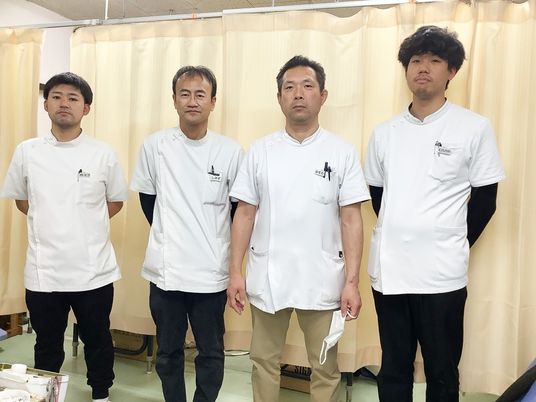 制服姿の男性4人が並ぶ休憩室  