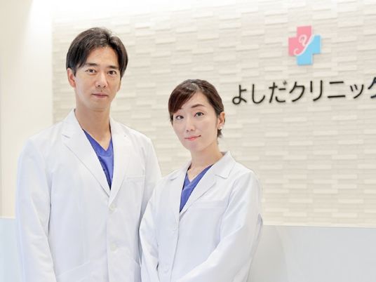 白衣のスタッフが並ぶ受付  