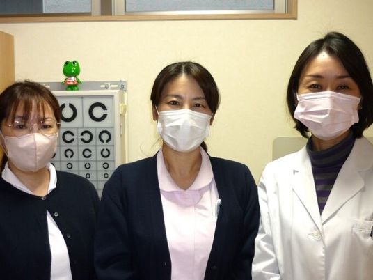 マスク姿の女性3人と視力表  
