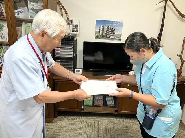 書類を渡すスタッフと職員の部屋  