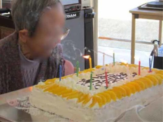 お祝いのケーキを前にする人