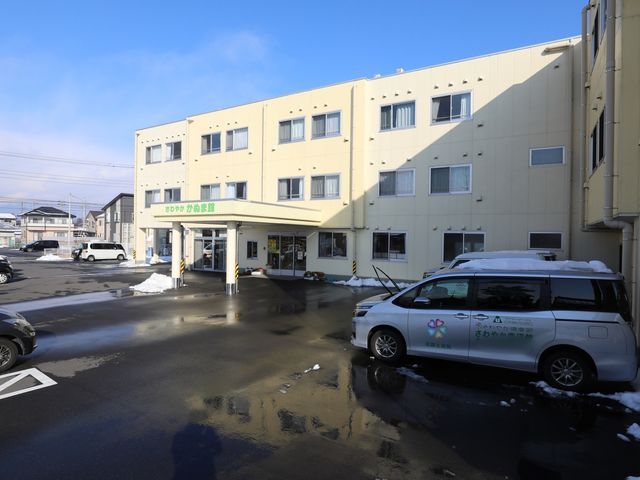 雪景色の施設外観 外観 広々とした駐車場が確保されており、清潔感のある外観が印象的です。職員用の車両も停車しており、アクセスの良さがうかがえます。