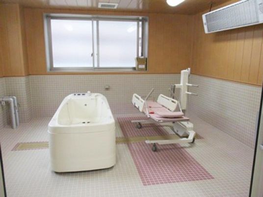 浴槽と介助用椅子のある室内