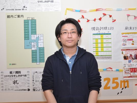 案内掲示板前のスタッフ