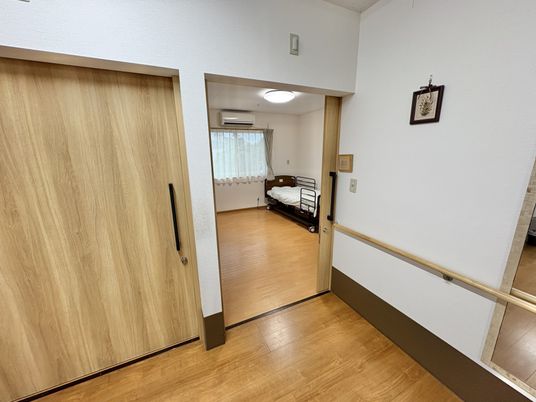 木の扉とベッドがある居室