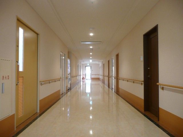 長い廊下 廊下 手すりが設置された長い廊下は、安全に配慮された移動が可能で、自然光も取り入れられています。