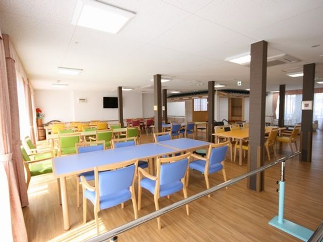 色とりどりの椅子が並ぶ部屋 リビング 広々とした空間には、色とりどりの椅子が並び、自然光が温かく差し込みます。くつろぎのひとときを過ごせます。