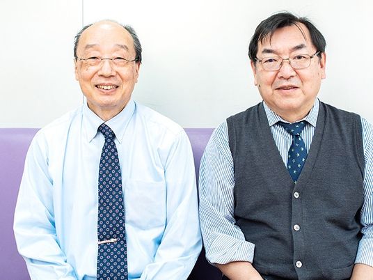 スタッフ2人が並ぶ室内  