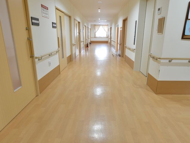 広々とした明るい廊下 廊下 無機質でなく暖かみのあるデザインの廊下です。手すりが整備され、安全に配慮された落ち着いた空間が広がっています。