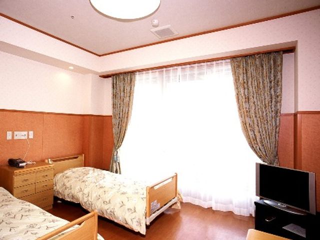 清潔感ある居室風景 二人部屋 ゆとりある空間の居室です。木製の家具や柔らかな照明が温かみを感じさせ、快適な生活の支えとなるでしょう。