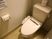 トイレはアイボリー系で統一した明るい空間である。便座には温水洗浄と暖房機能があり、操作パネルは本体の横に付いている