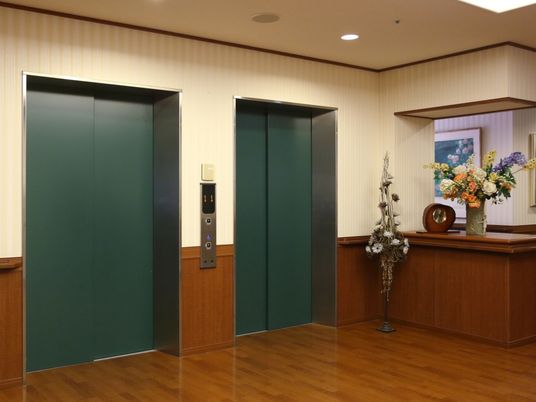 エレベーター前のフロアはフローリングで、ゆったりとした広さがある。カウンターには季節の花を飾っている。