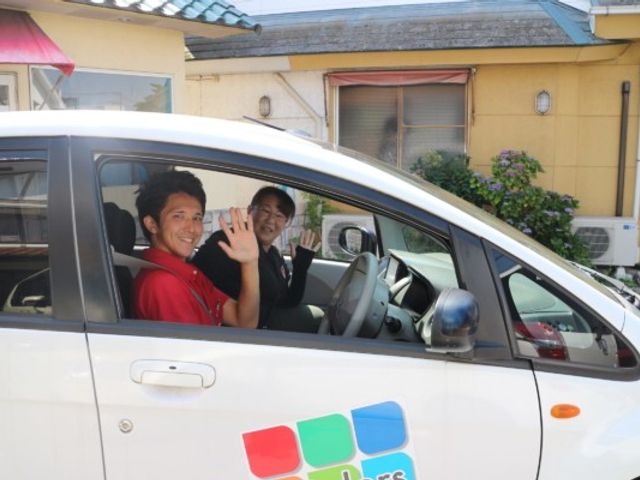 笑顔のスタッフの車 外観 スタッフが施設の車で笑顔を見せています。アットホームで温かみのある職場です。