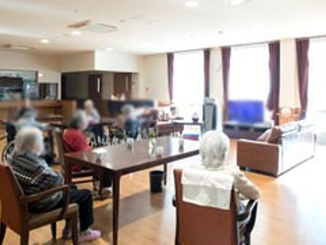 広々としたリビング リビング 広々とした明るい空間で、入居者の方々がくつろいで談笑を楽しんでいます。自然光が差し込む穏やかな雰囲気です。