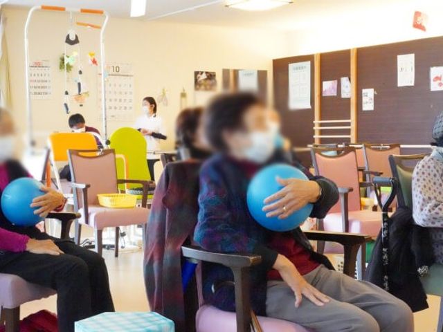 活動する人々の部屋 機能訓練室 ゆったりとした空間で、入居者の方々がボールを使ったリハビリ活動を楽しまれています。